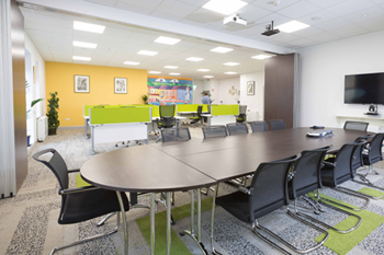 Conference room in Kilrush Digital Hub with its dividing partition open and hot-desks in background