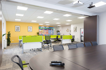 Conference room in Kilrush Digital Hub with its dividing partition open and hot-desks in background